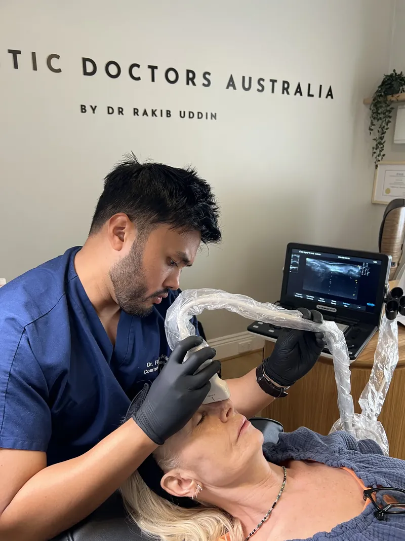 Dr Rakib Uddin performing an ultrasound facial scan before treatment