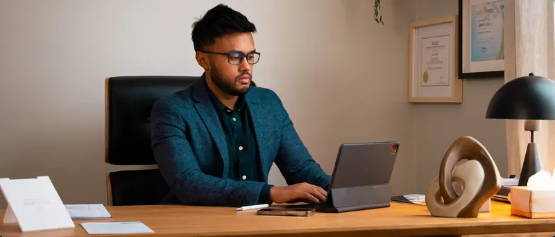 Dr Rakib Uddin reviewing a body treatment plan at his desk