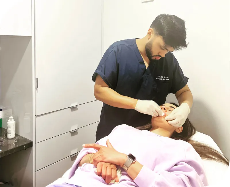 Dr Rakib performing a lip enhancement treatment on a reclining patient